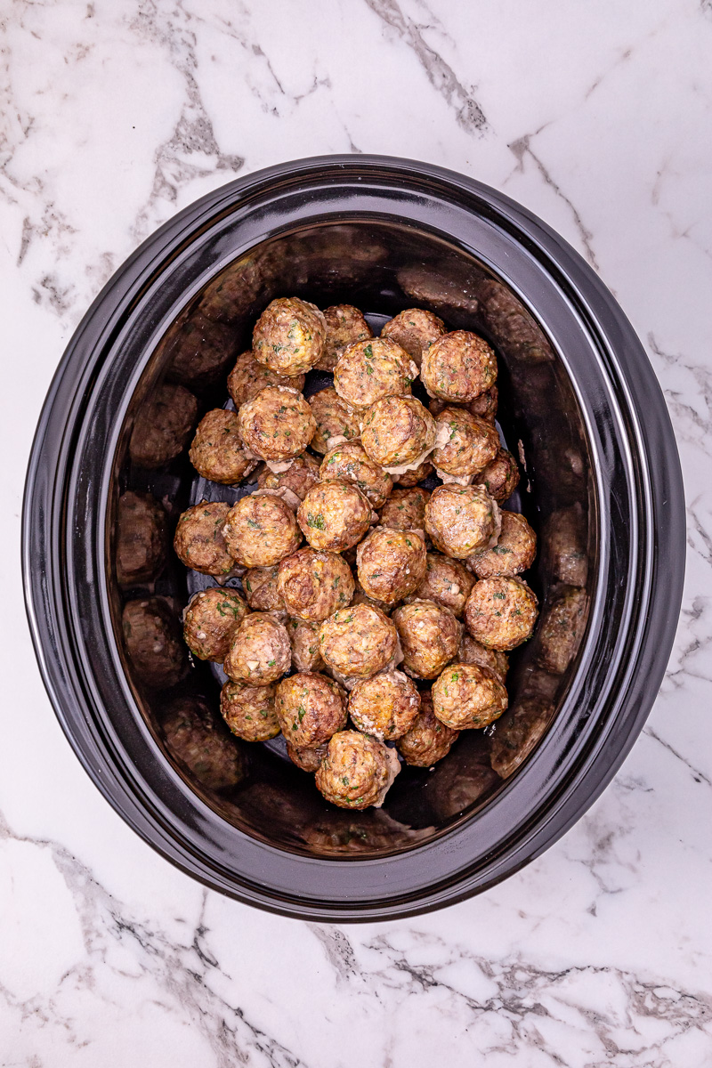 Meatballs are placed in bottom of crockpot.