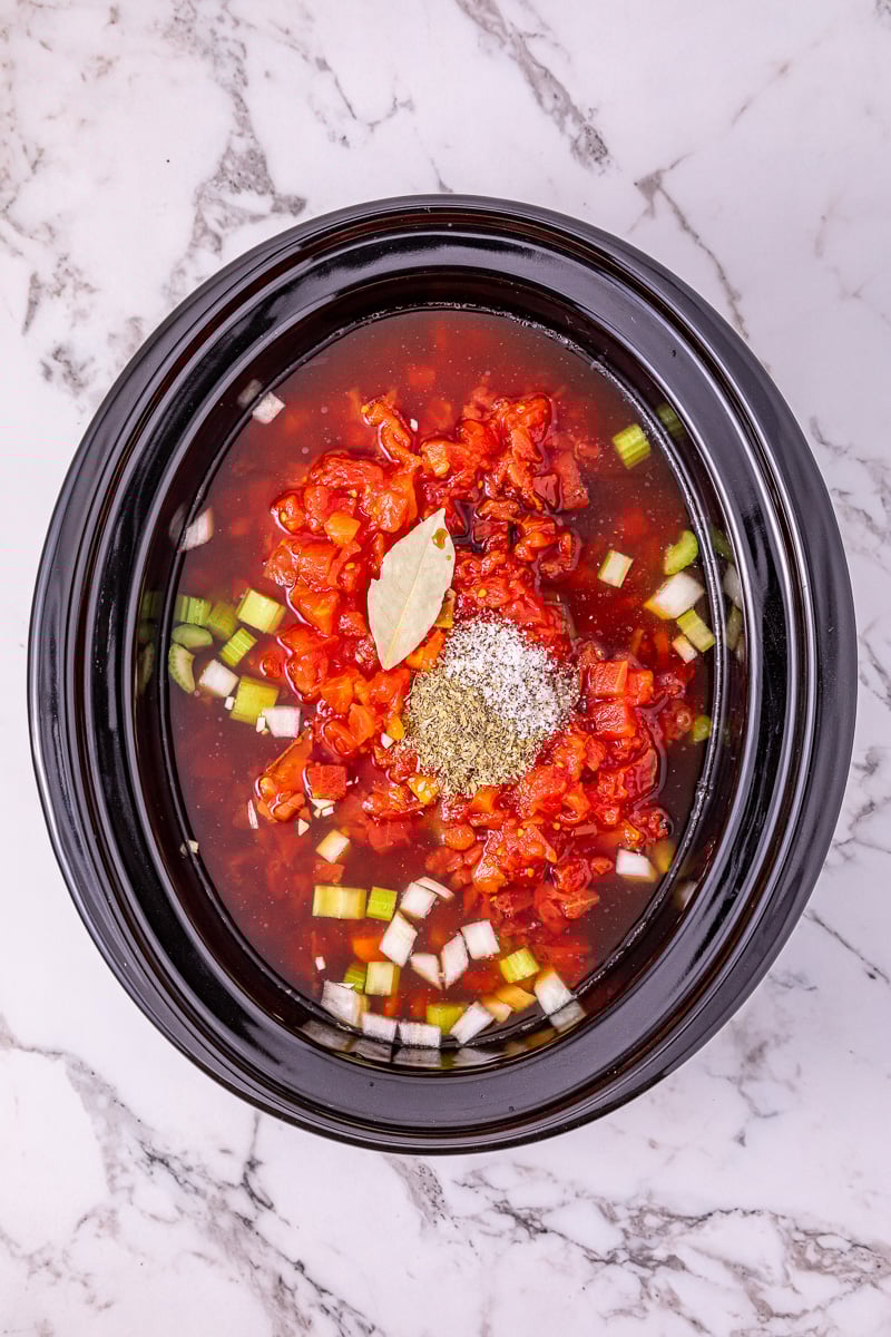 Veggies are added to crockpot on top of meatballs.