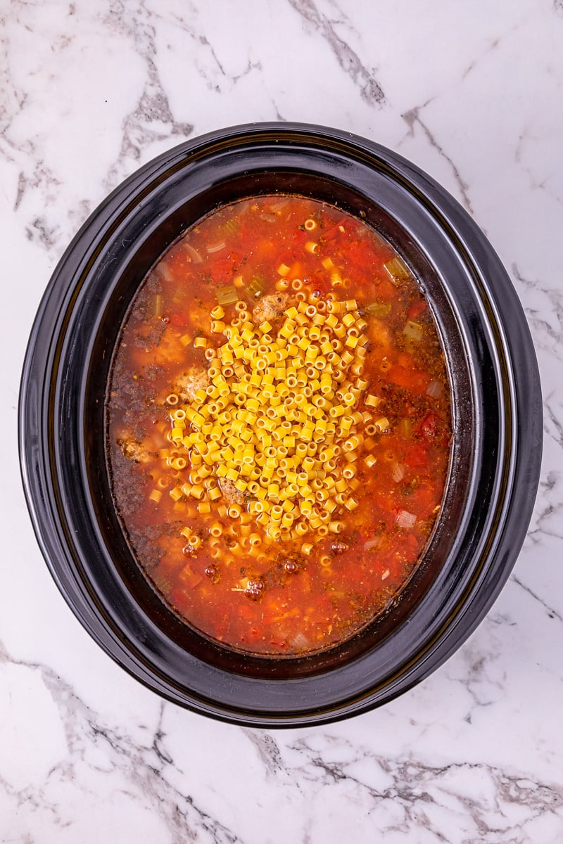 Dried pasta is added to the crockot.