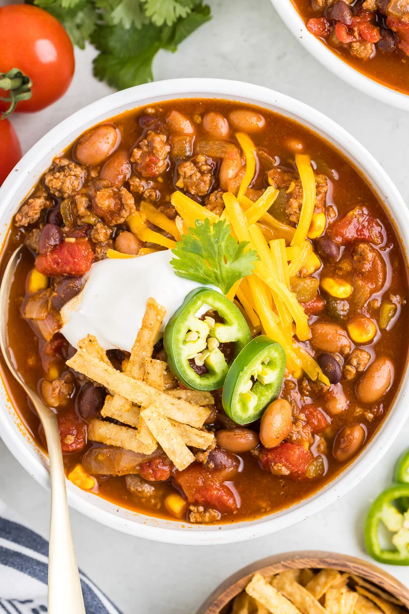 Taco soup garnished with jalapenos, shredded cheese and taco strips with sour cream.
