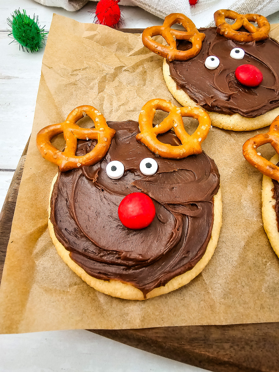 Reindeer sugar cookies on wooden board.