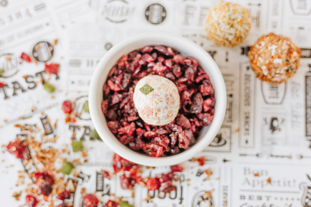 Individual mini cheese balls rolled in dried cranberries.