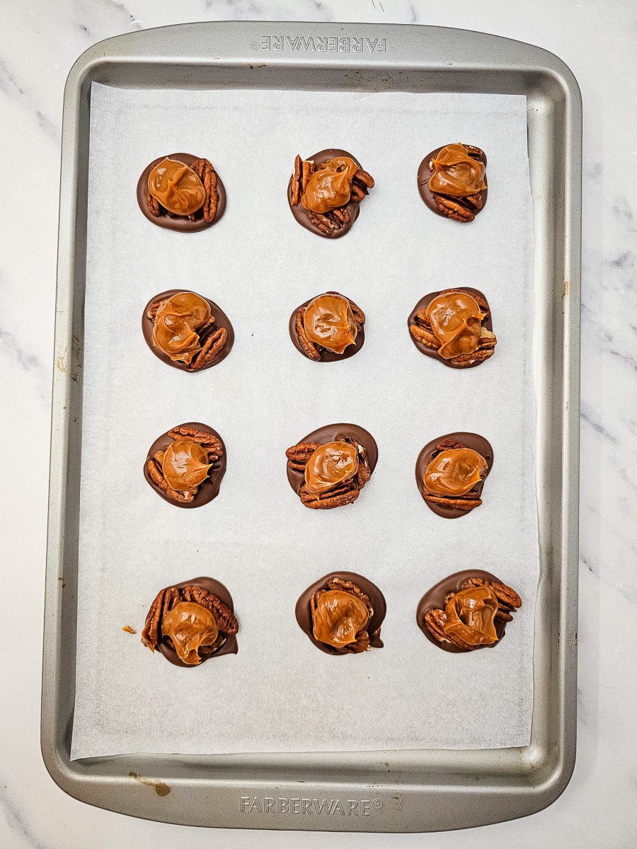Carmel is added to the top of pecans.