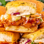 BBQ chicken sliders with coleslaw on a plate.