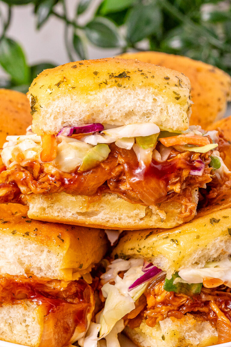 BBQ chicken sliders with coleslaw on a plate.