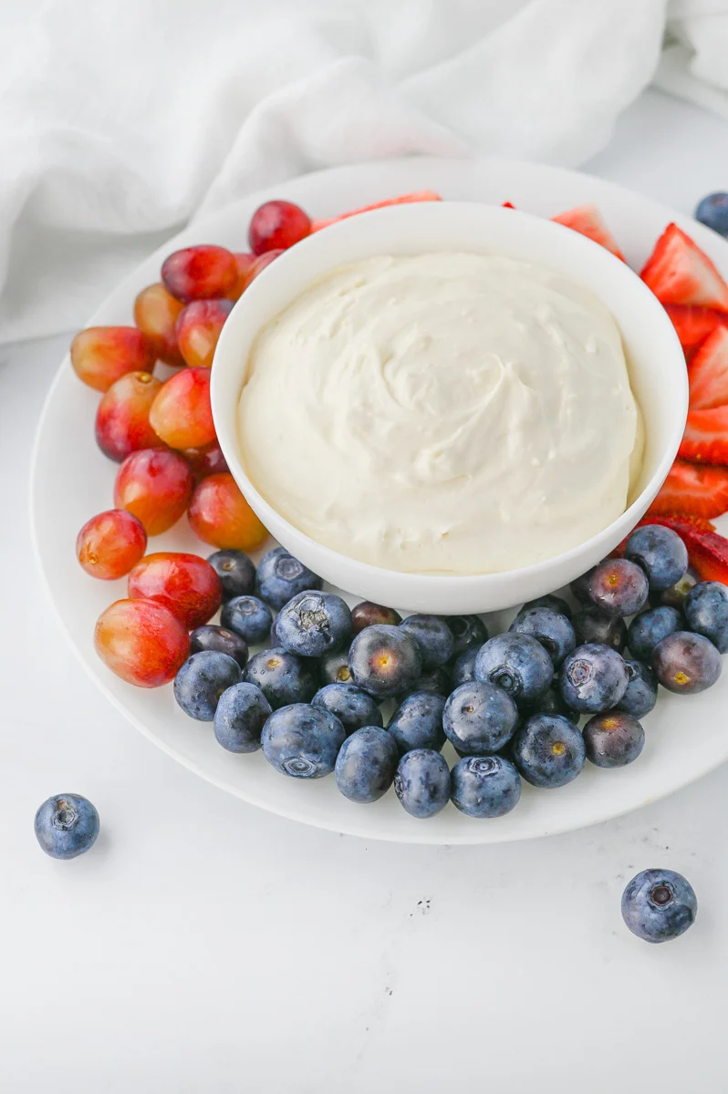 Marshmallow fruit dip in bowl with fresh fruit on the side.
