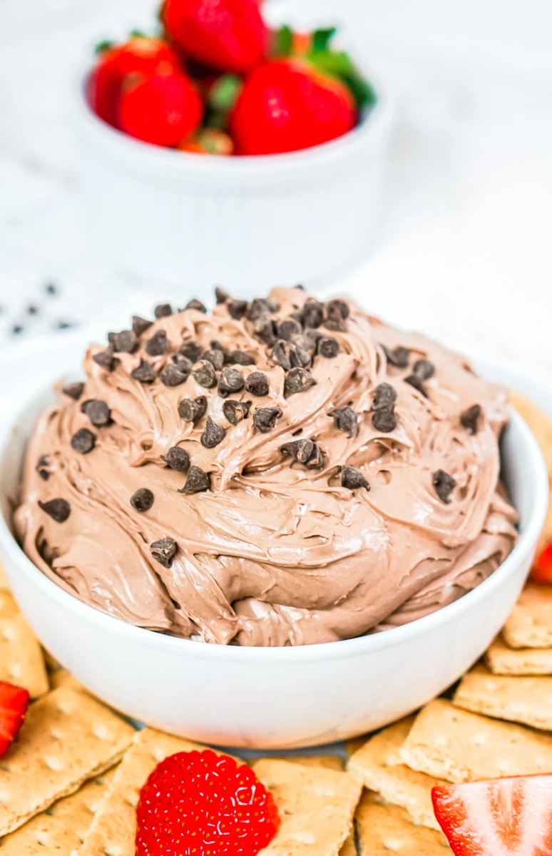 Brownie batter dip served in bowl with Graham crackers and strawberries on the side.