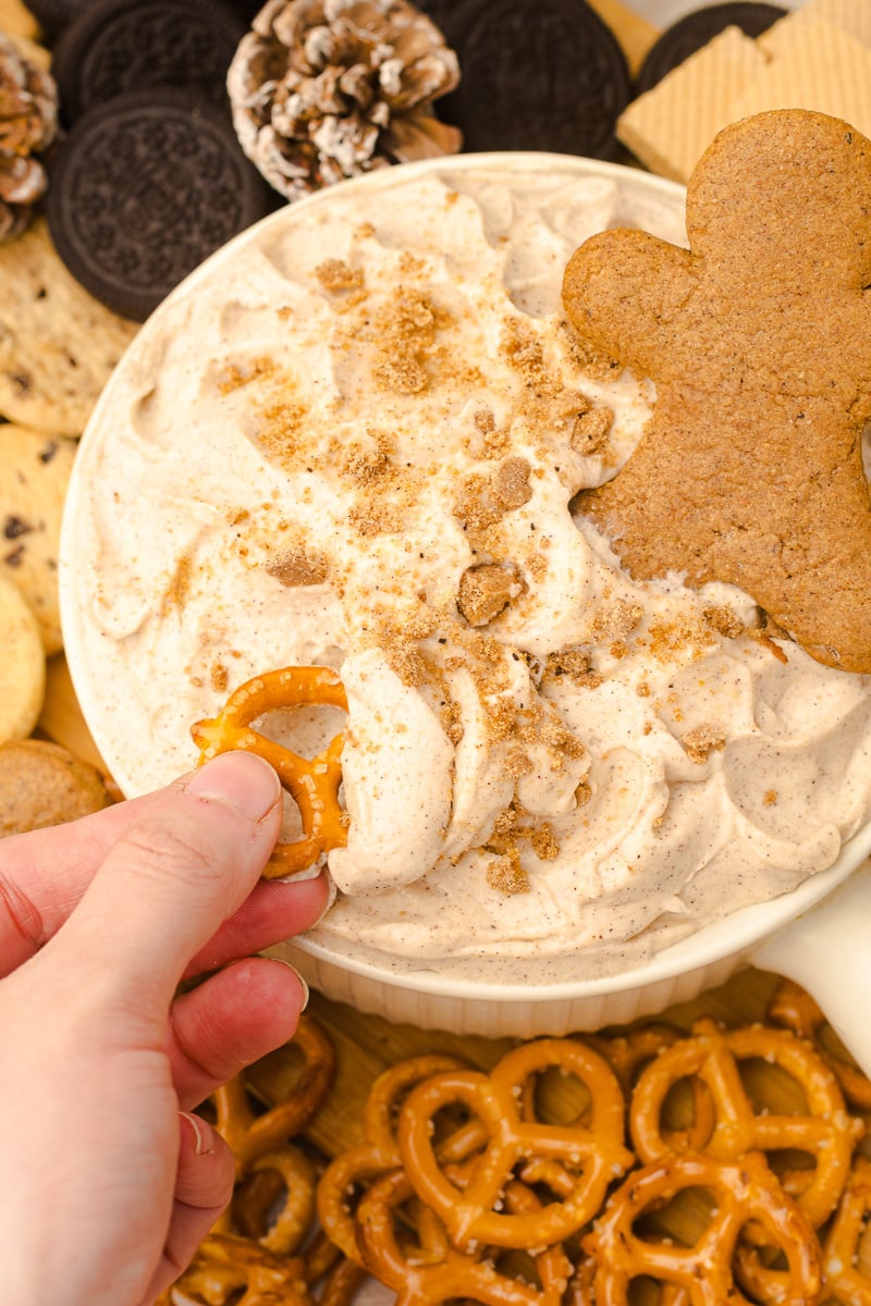 A cookie is dipped into the gingerbread cream cheese dip.