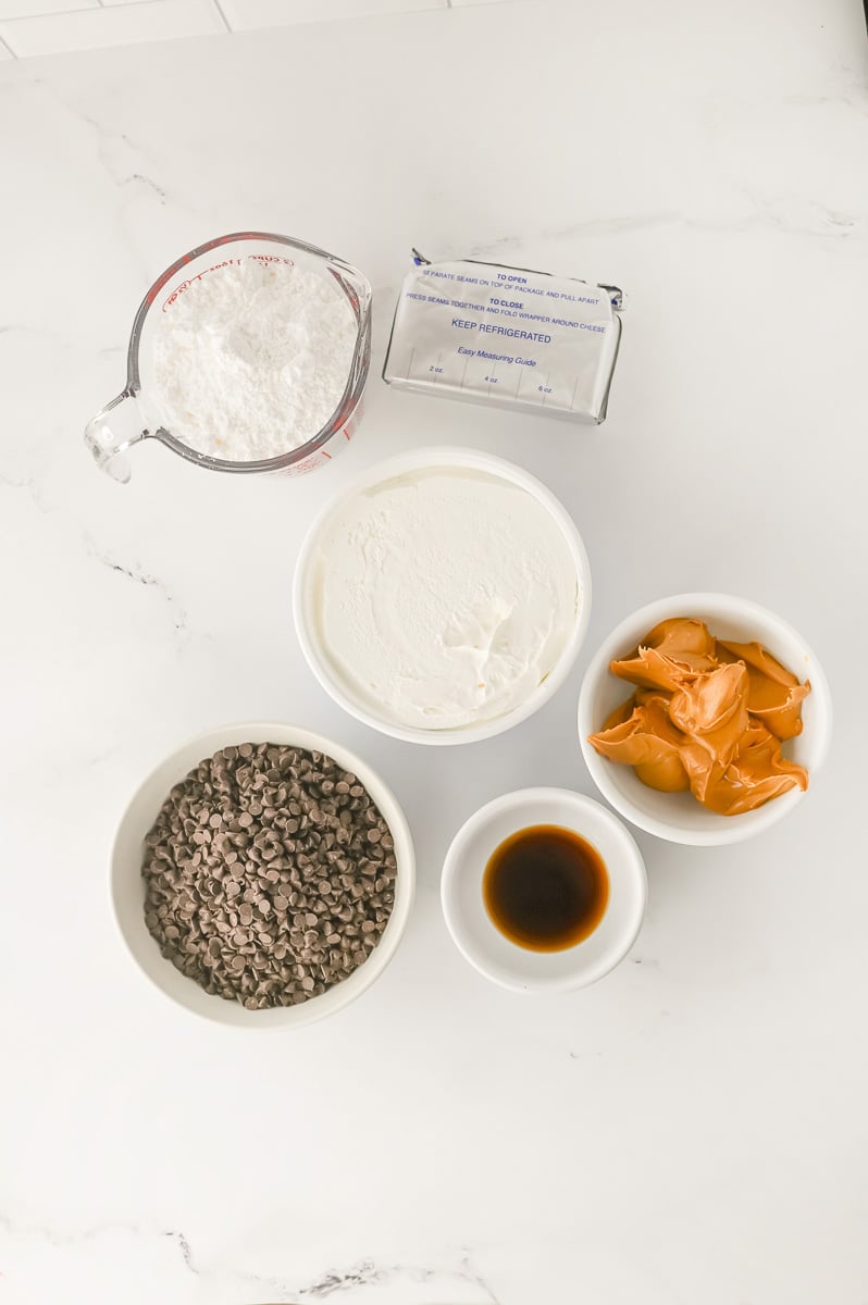 Ingredients for peanut butter dip in small bowls in counter in preparation for the recipe.