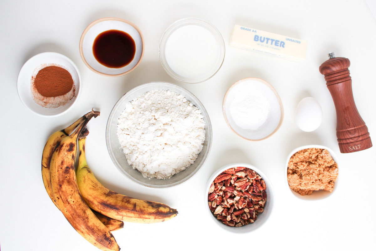 Ingredients for banana bread pancakes laid out in small bowls on counter.