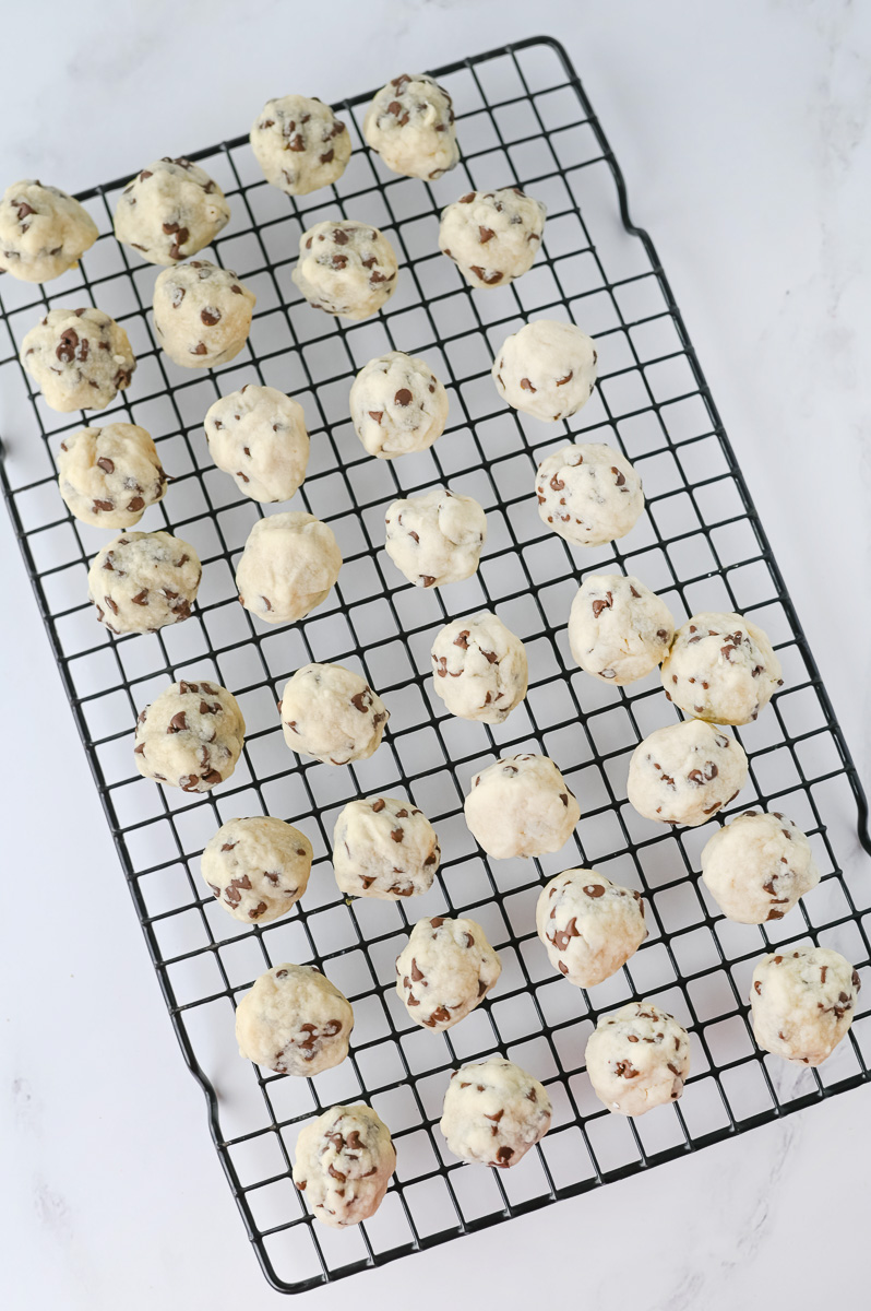 Baked snowball cookies on wire cooling rack.