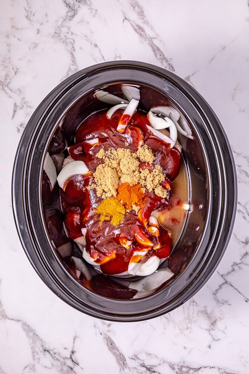 BBQ sauce, brown sugar, apple cider vinegar, paprika, and cayenne are added to the crockpot.