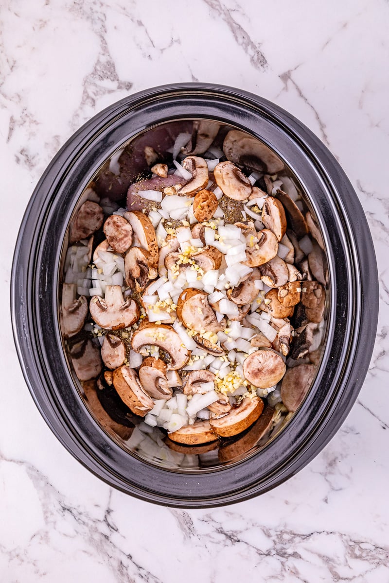 Mushrooms and garlic are added to the top of the turkey tenderloins.