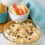 Buckeye dip in glass bowl with sliced apples in small bowl on the side.