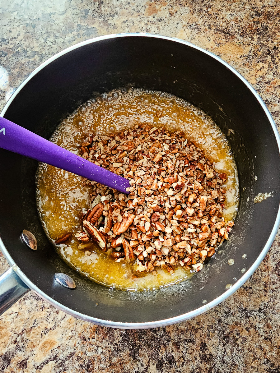 Pecans are adde to butter mixture in saucepan.