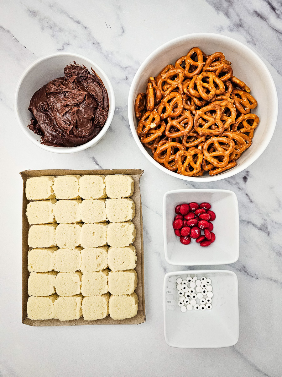 Ingredients for reindeer sugar cookies laid out in bowls on counter in preparation for the recipe.