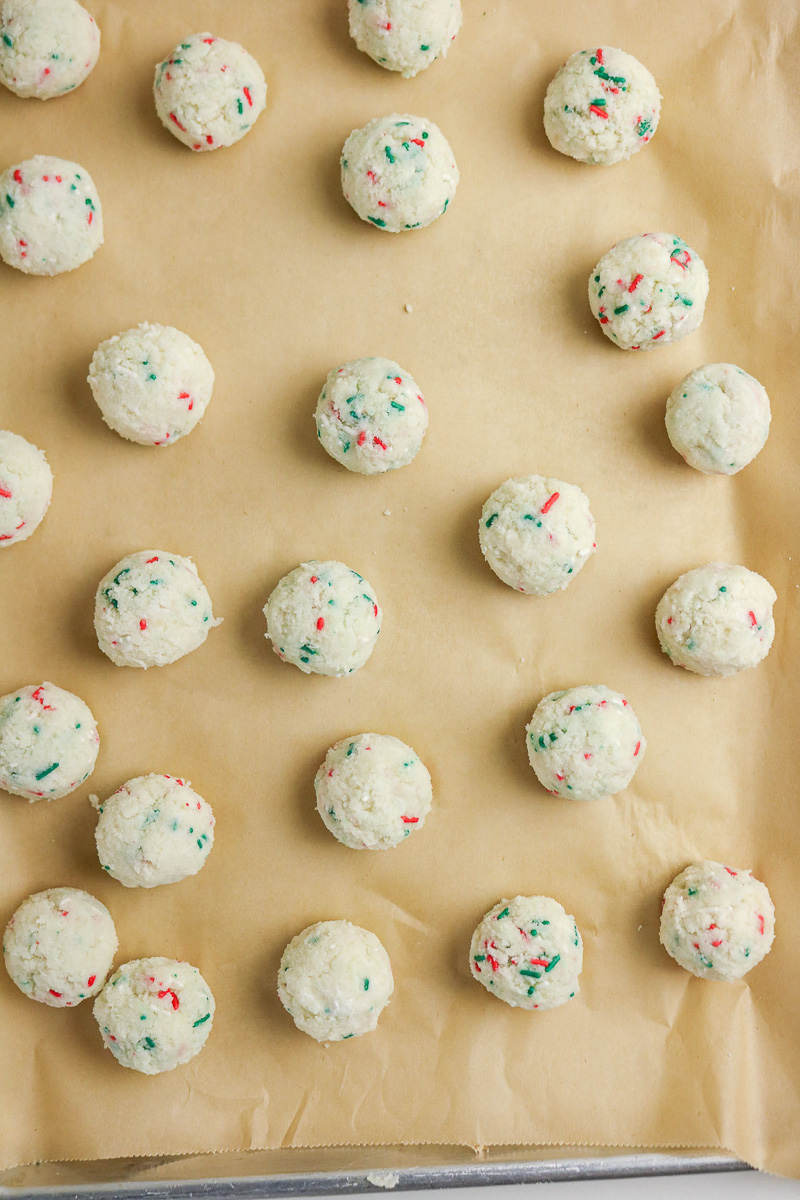Rolled cake ball mixture on baking sheet.