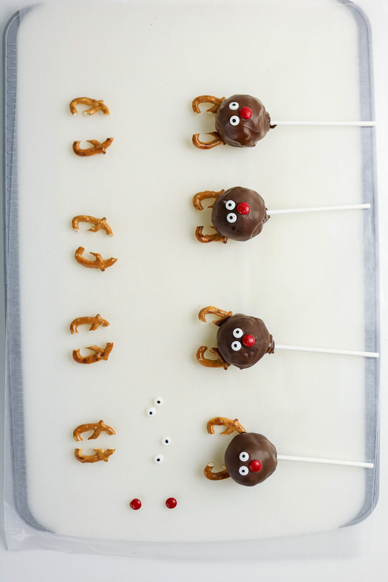Reindeer cake balls on parchment lined baking sheet.
