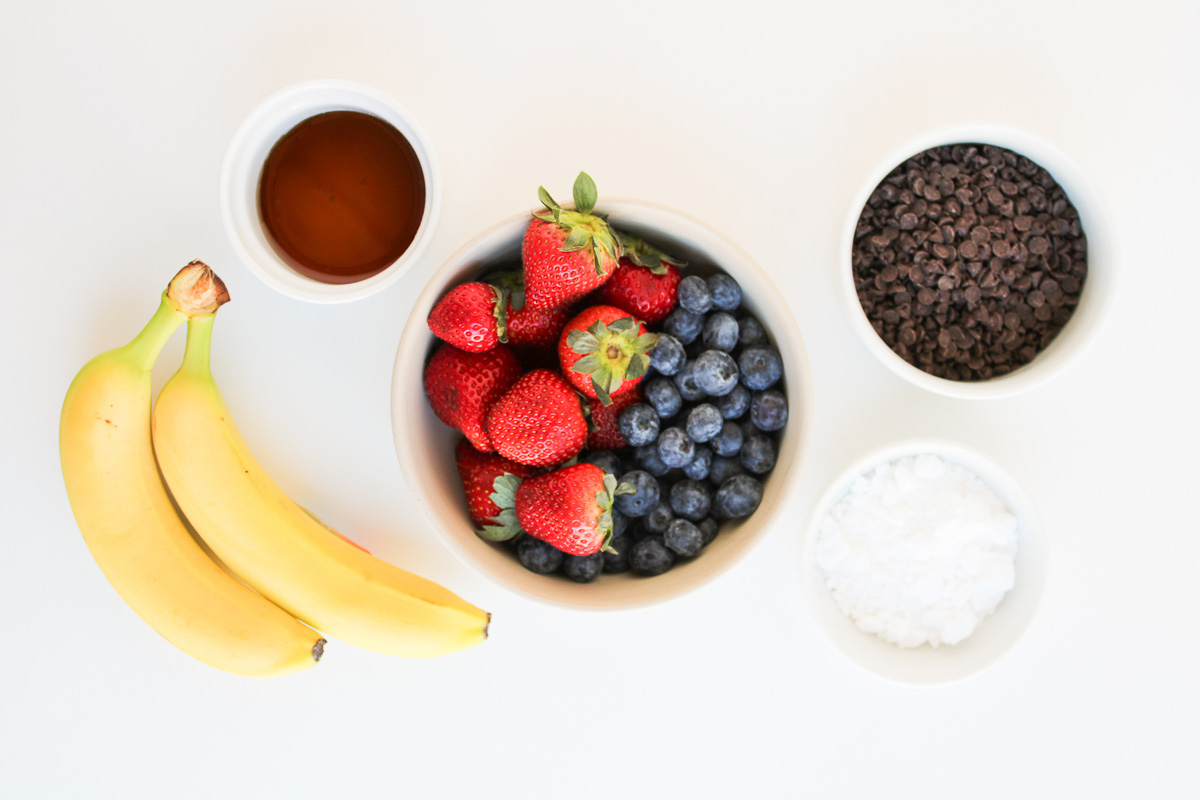 Toppings for sheet pan pancakes in small bowls on counter.