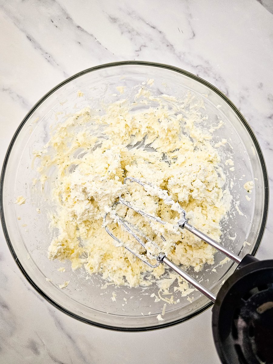 Ranch seasoning mix is added to cream cheese mixture in bowl.