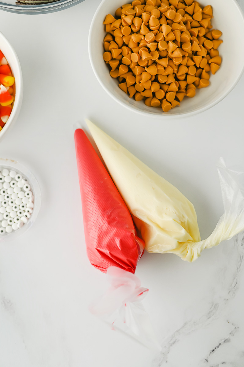 Red and white frosting prepped in bags.