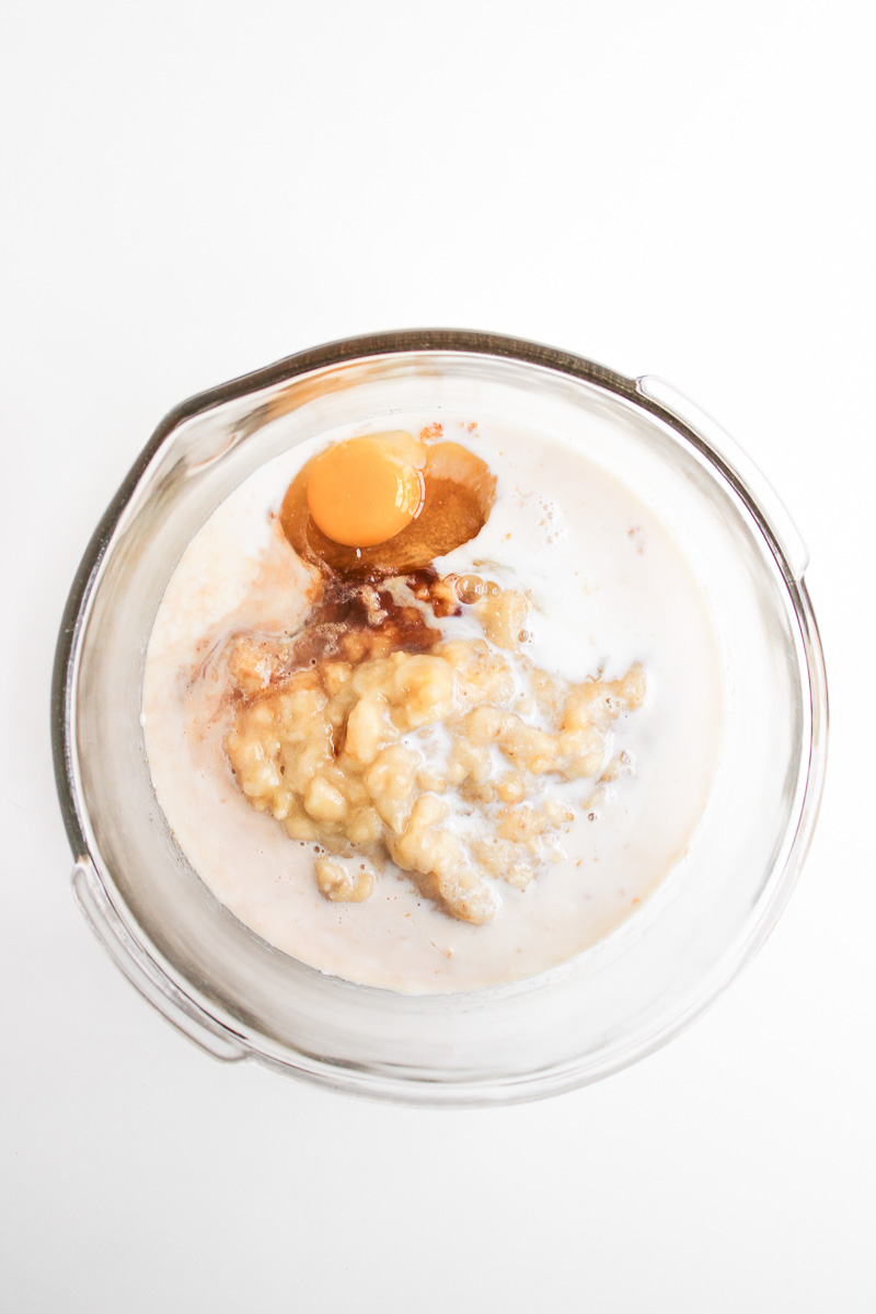 Milk, eggs, banana and vanilla in mixing bowl.