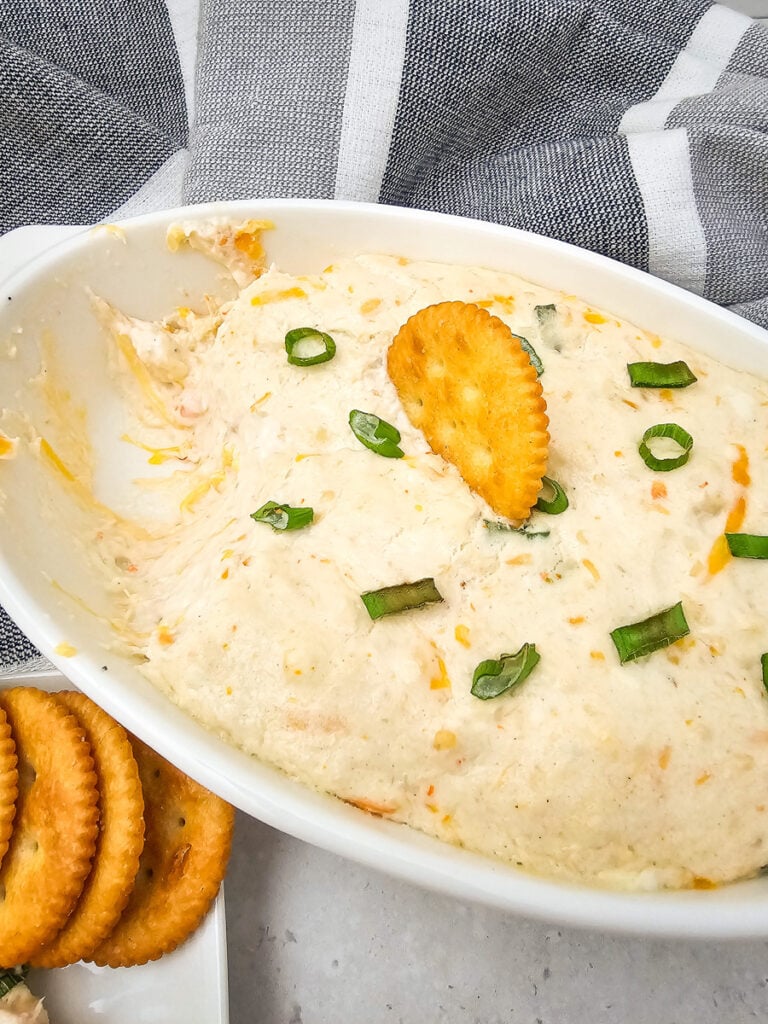 Hot seafood dip in white dish.