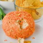Cheese ball on plate and taco is covered in cheese ball filling.