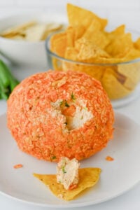 Cheese ball on plate and taco is covered in cheese ball filling.