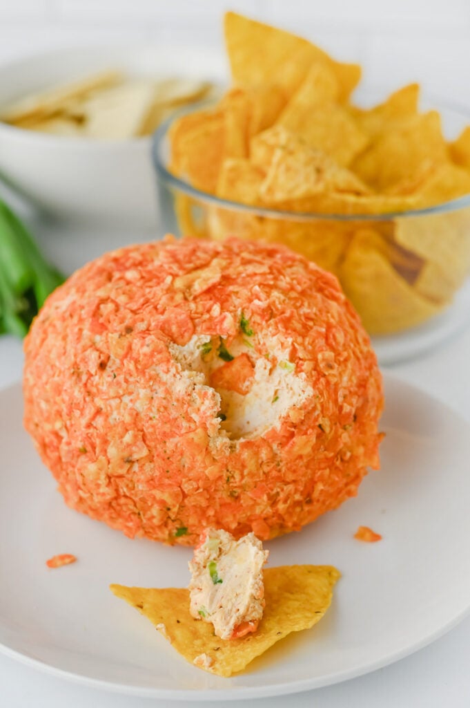 Cheese ball on plate and taco is covered in cheese ball filling.