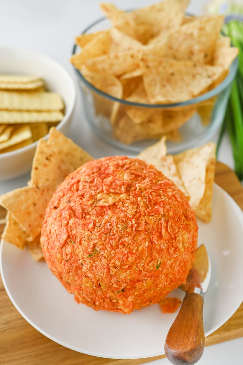 Taco cheese ball on plate with Doritos.