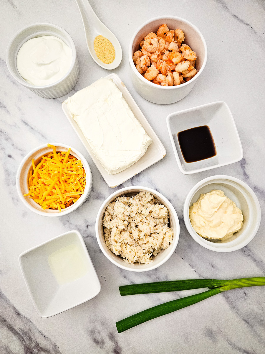 Ingredients for hot seafood dip in small bowls on counter in preparation for the recipe.