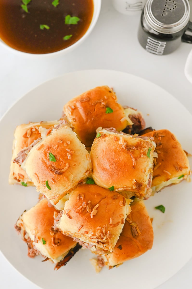 French dip sliders overhead view on white plate.