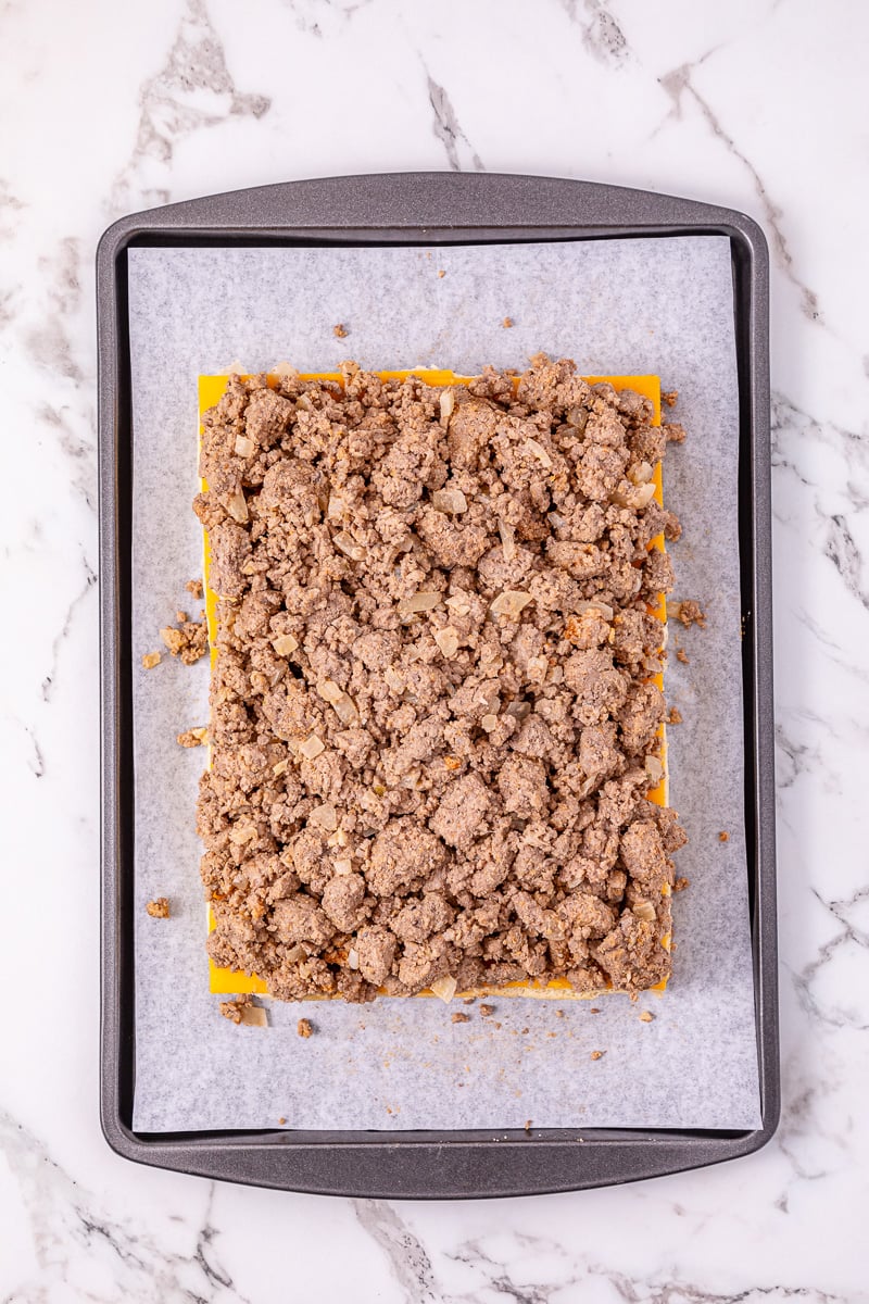 Ground beef mixture is placed on top of cheese layer on slider buns.