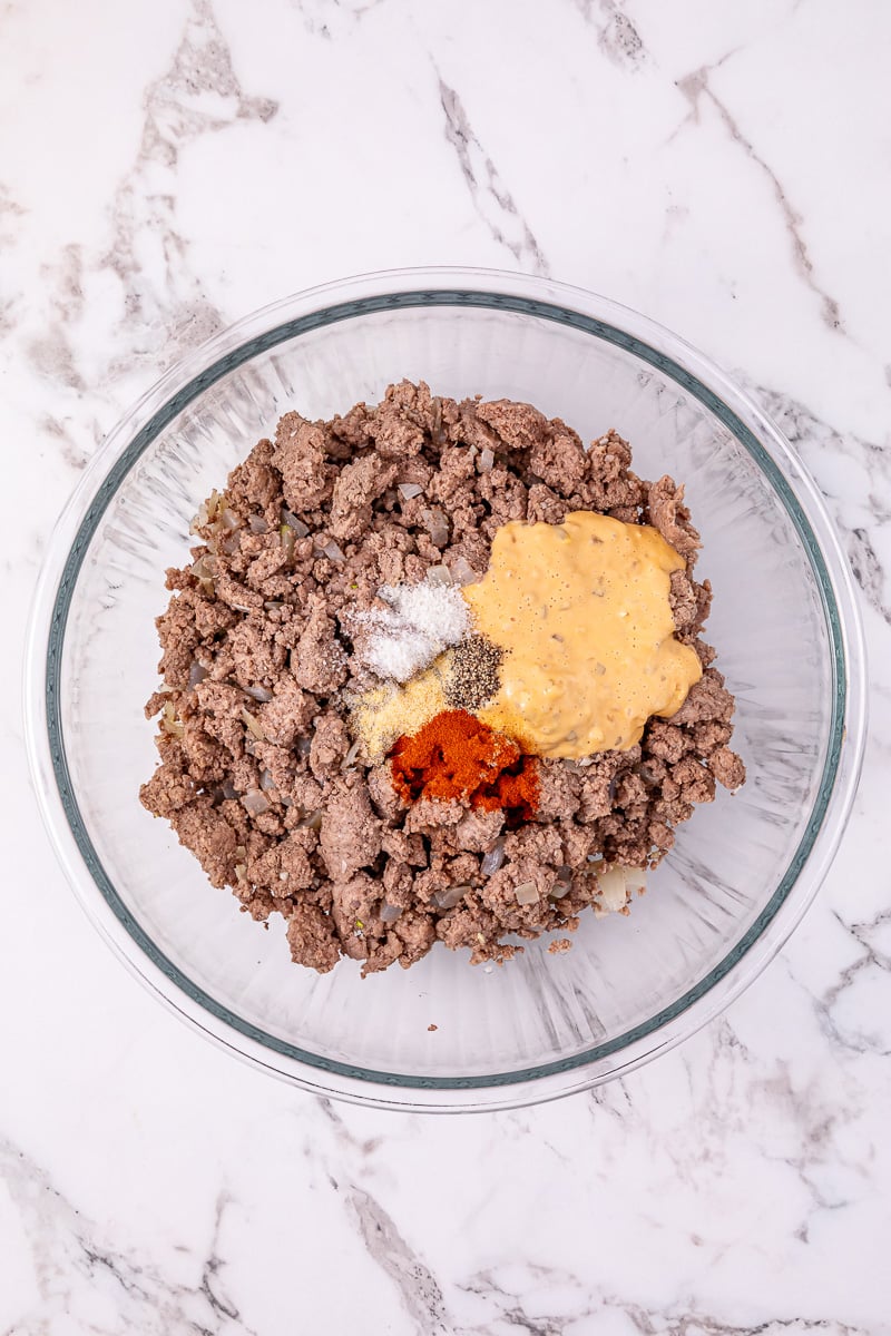 Seasoning and sauce is added to the ground beef mixture.