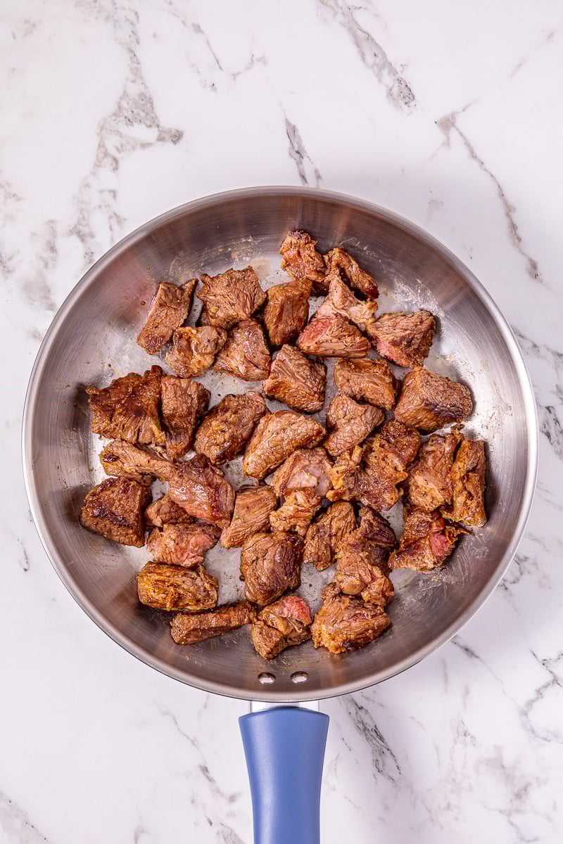 Seared beew stew meat in skillet ready to be added to the crockpot.