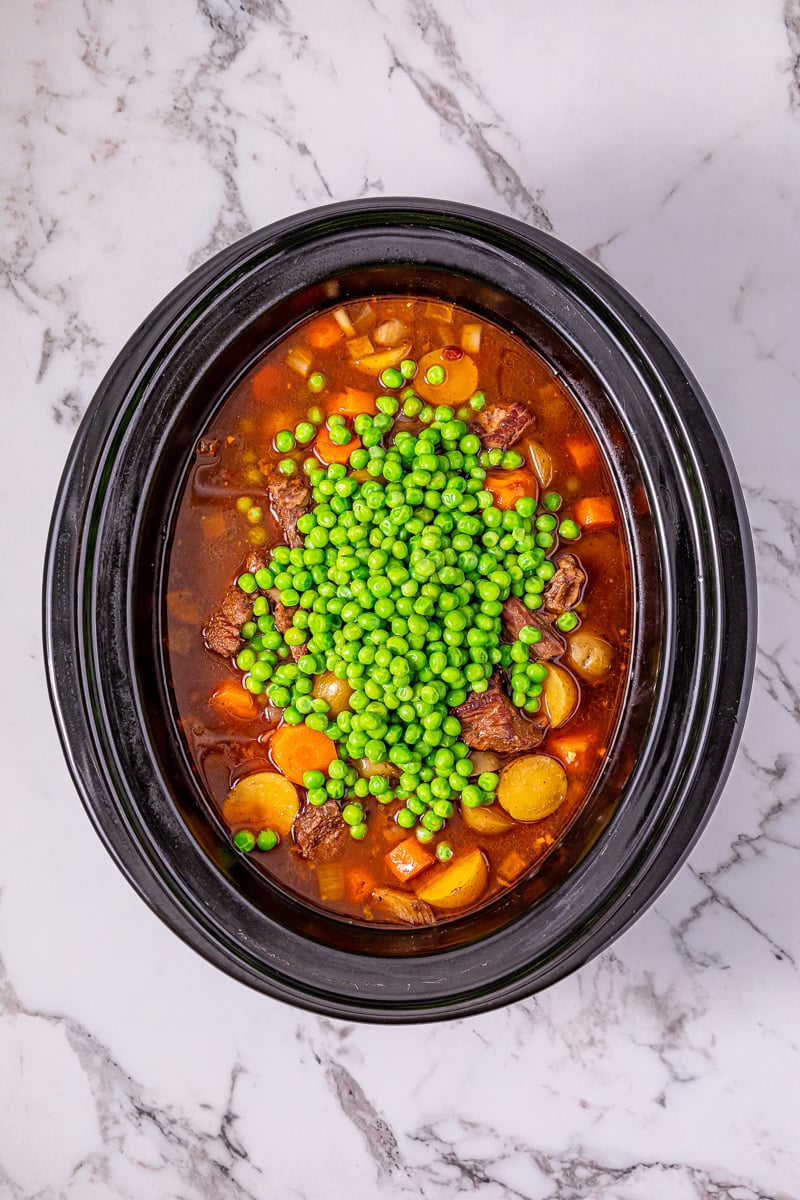 Peas are added to the crockpot.