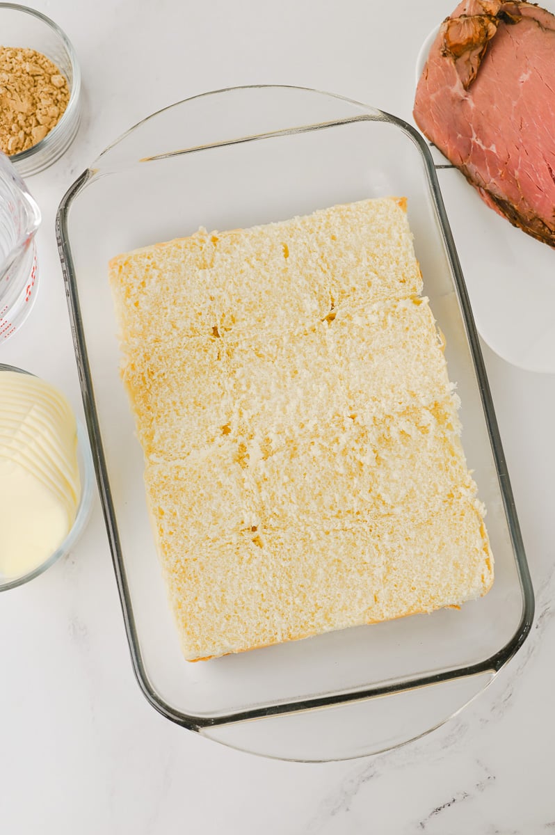 Bottom half of slider buns in baking dish.