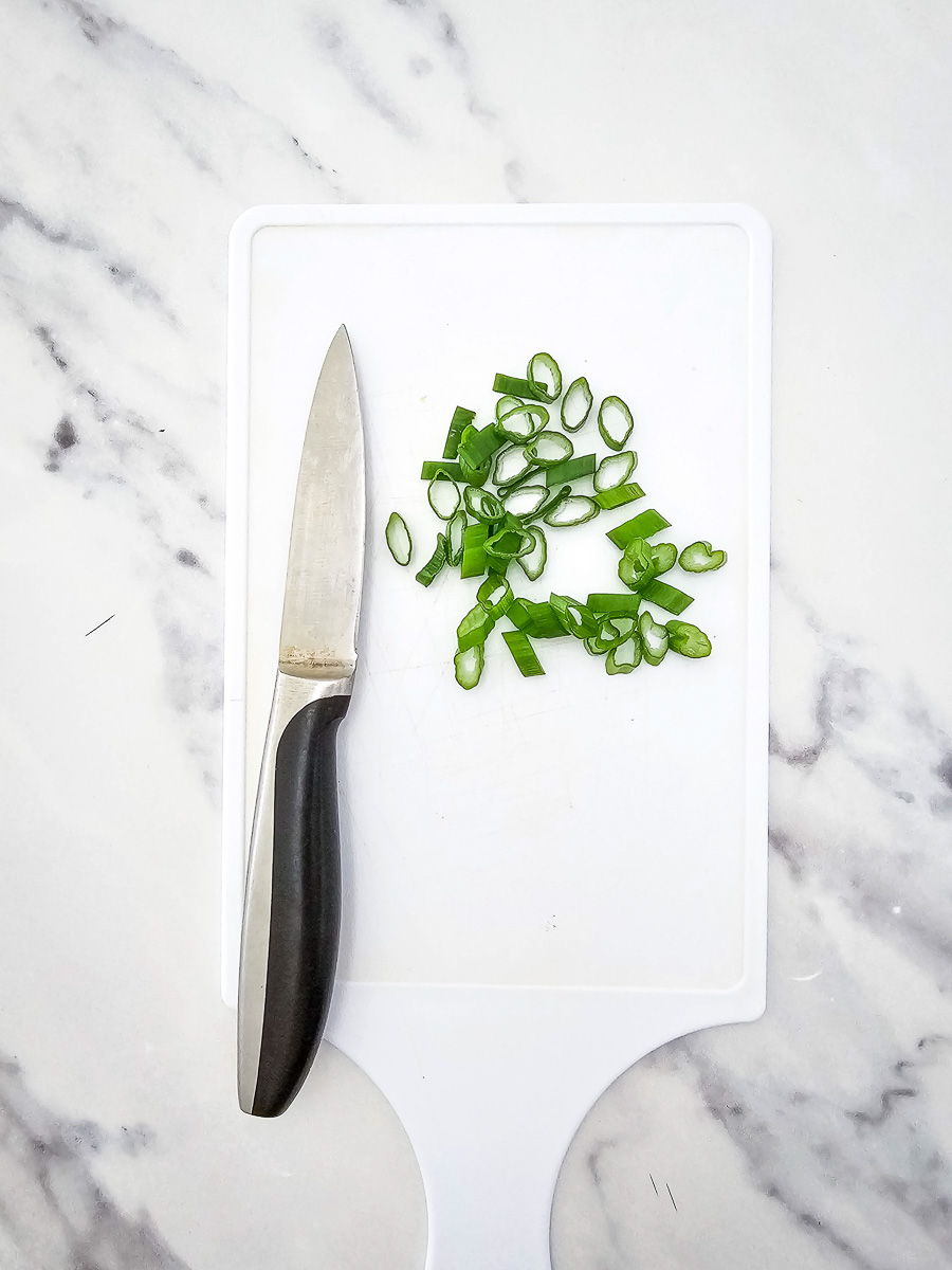 Sliced green onions on cutting board.