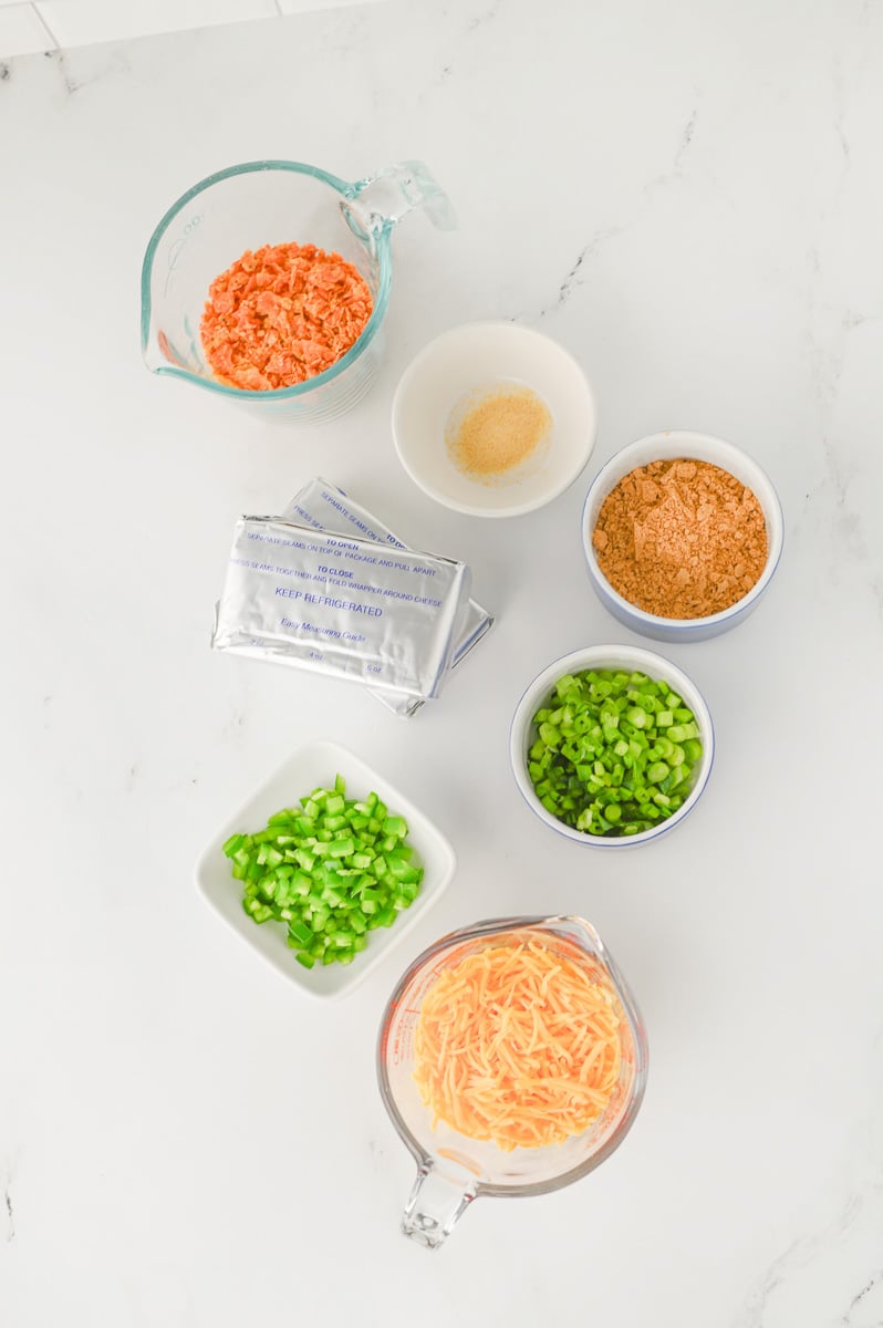 Ingredients for taco cheese ball in small bowls on counter in preparation for the recipe.