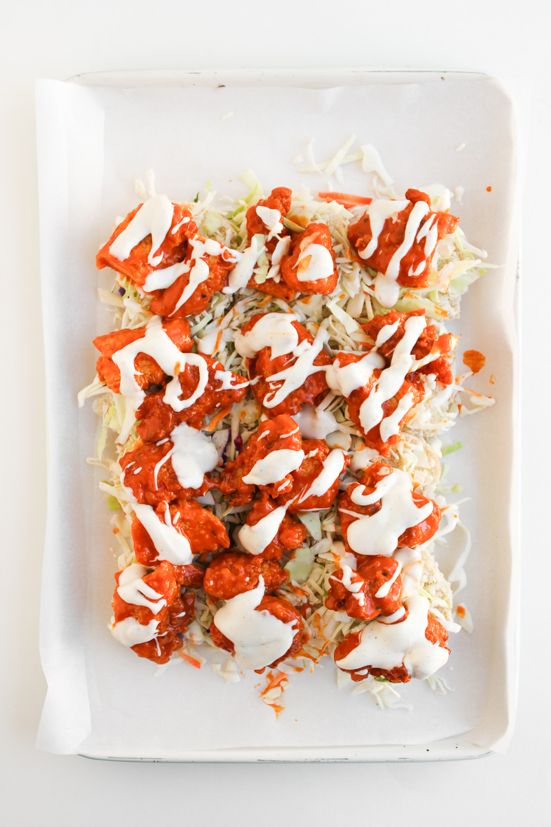 Coleslaw, sauce and chicken is layered on top of slider buns.