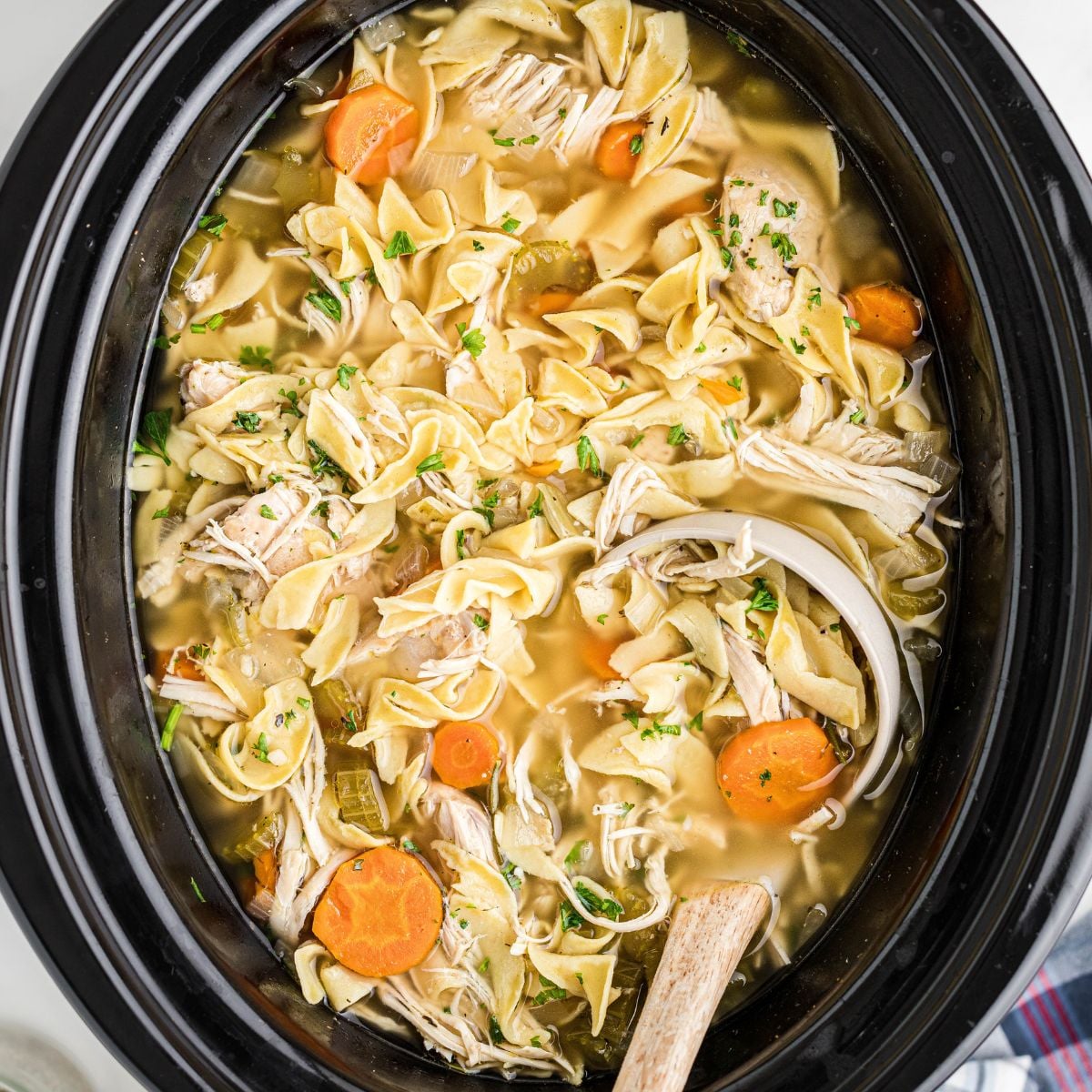 Chicken noodle soup in crockpot.