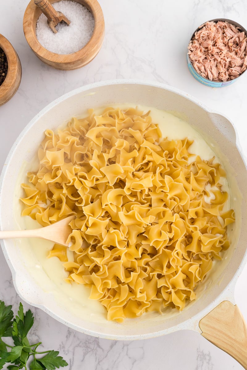 Cooked pasta is added to the skillet.