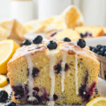 Bueberry lemon loaf cake on counter, drizzled with glaze.