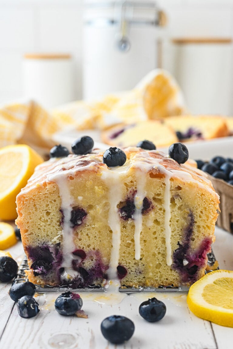 Bueberry lemon loaf cake on counter, drizzled with glaze.