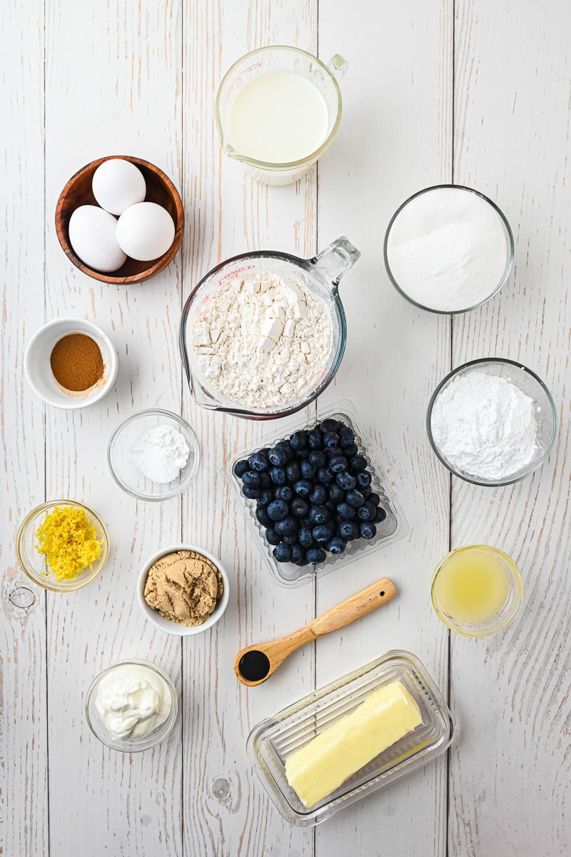 Ingredients for blueberry lemon loaf laid out on kitchen counter in small bowls.