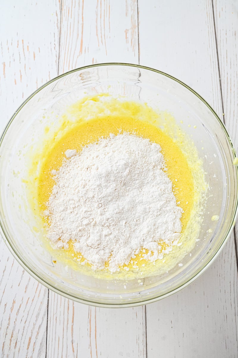 Dry ingredients are added to the wet ingredients in glass mixing bowl.