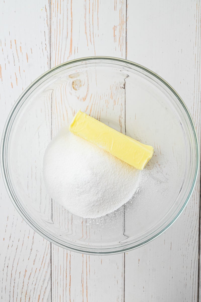 Butter and sugar in glass mixing bowl.