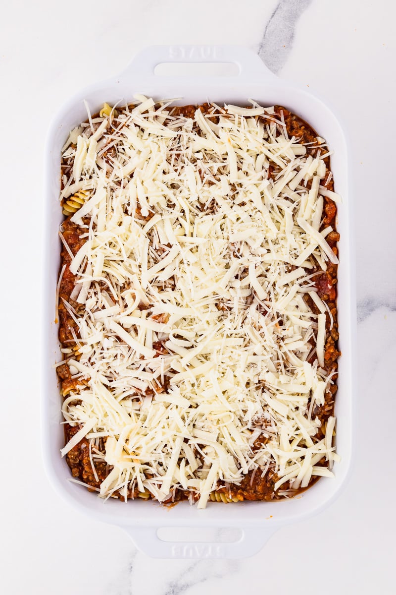 Cheeses are sprinkled on top of the pasta and sauce.