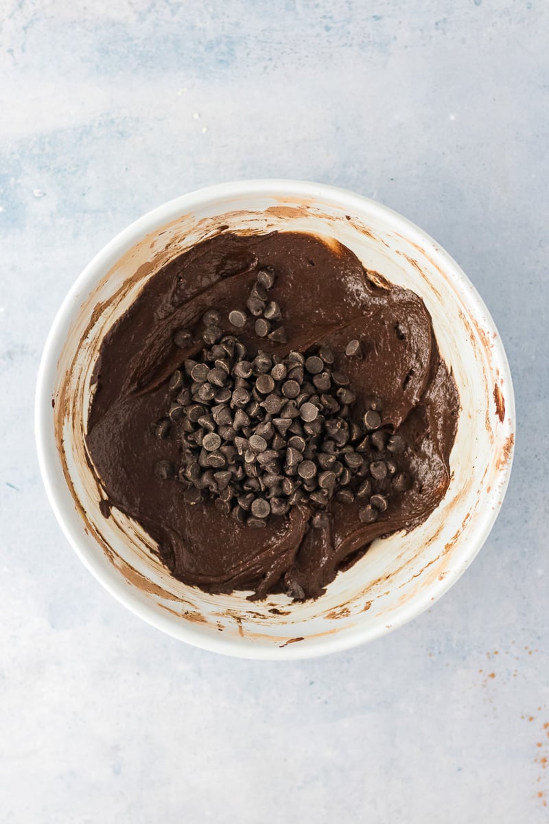 Cocoa powder and chocolate chips are added to the bowl.